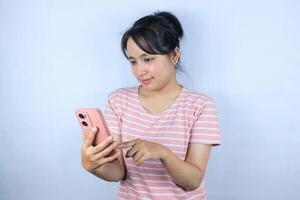 smiling expression asian woman reading good news on her smart phone on white background photo