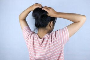 rear view asian woman tying her hair up isolated on a white background. photo