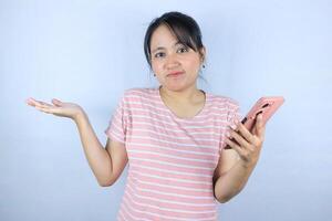 confuse expression of Asian woman holding smart phone on white background photo