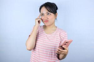 confuse expression of Asian woman holding smart phone on white background photo