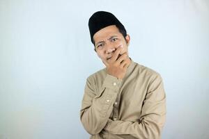 Confuse expression of asian muslim man doing thinking gesture, looking for idea on white background photo