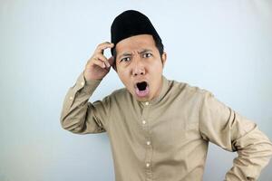 funny facial expression shock and confuse asian muslim men wearing cap isolated on white background photo