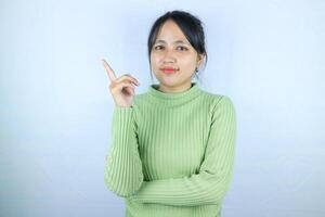 Portrait Asian beautiful young woman smiling standing pointing finger out on white background photo