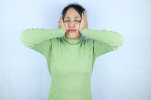 Asian woman suffering from headache desperate and stressed because pain and migraine. Hands on head. photo