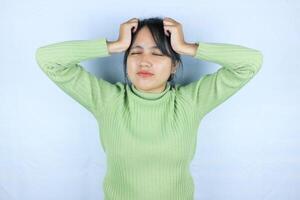 Asian woman suffering from headache desperate and stressed because pain and migraine. Hands on head. photo