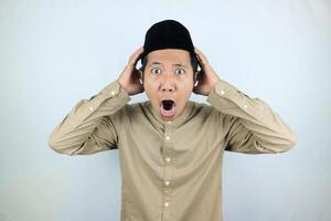 funny shocked and surprise expression asian muslim men wearing cap isolated on white background photo