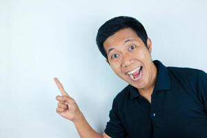 Asian man expression smiling while pointing to the side presenting the product. advertising concept photo