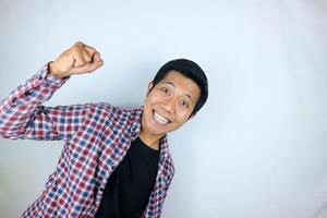 yes, happy expression of asian man clenching his fists. victory concept, isolated white background photo