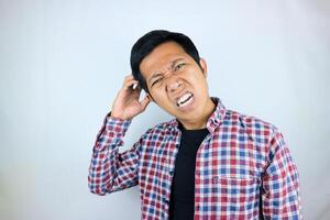funny facial expression of asian man confused and scratching his head, questioning the problem photo