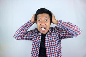 funny facial expression of stressed asian man holding his head, isolated on white background photo