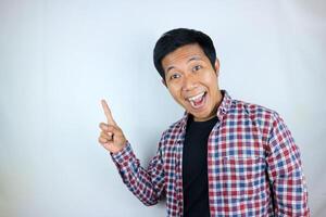 Asian man expression smiling while pointing to the side presenting the product. advertising concept photo