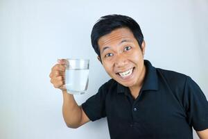 sonriente cara expresión joven asiático hombre sostener Bebiendo vaso. cuidado de la salud concepto foto