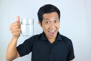 sonriente cara expresión joven asiático hombre sostener Bebiendo vaso. cuidado de la salud concepto foto