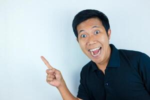 Asian man expression smiling while pointing to the side presenting the product. advertising concept photo