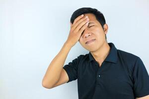 funny facial expression of stressed asian man holding his head, isolated on white background photo