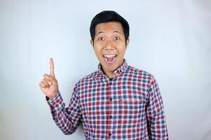 Asian man smiling while pointing up presenting product. advertising concept photo