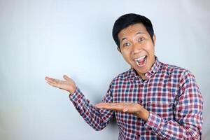 Asian man expression smiling while pointing to the side presenting the product. advertising concept photo