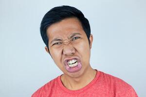 funny facial of asian man surprised and dumbfounded, he looks at the camera grimacing his mouth photo