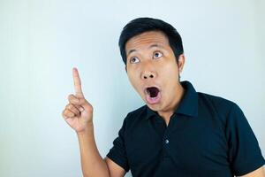 funny facial expression of asian man shocked and surprised while pointing at up side photo