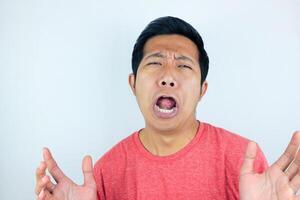 funny expression of shocked and surprised Asian man wearing a red t-shirt looking at the camera photo