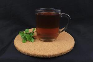 tea with mint in glass with fresh mint leaves around. Homemade refreshing drink. photo