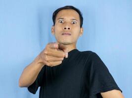enojado joven asiático hombre expresión con señalando gesto y abultado ojos. mental salud concepto foto