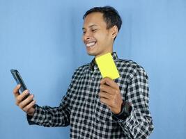 Happy expression handsome asian man hold paper money banknotes and empty card. photo