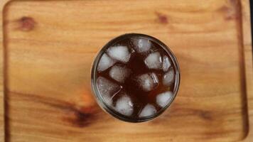 Glass of lemon ice tea isolated on wooden table. From top view photo