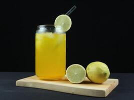 Cool freshly made lemonade and fruits on wooden tray . dark background. side view, close-up view. photo