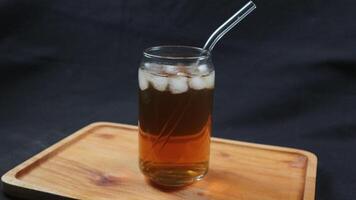 Glass of tasty Long Island iced tea on dark background with space for text photo