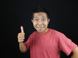 funny expression of asian man giving thumbs up isolated on white background photo