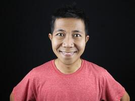 Asian man smiling looking at camera with happy face on black background for character photo