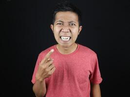 asian man pointing his teeth with surprised and annoyed expression photo