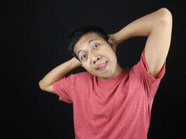 funny expression of asian man with hand on head isolated on black background photo