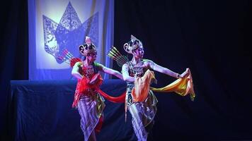 Traditional dancers performing with shadow puppet backdrop video