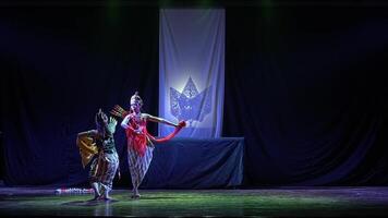 Traditional dance performance on stage with leaf backdrop video