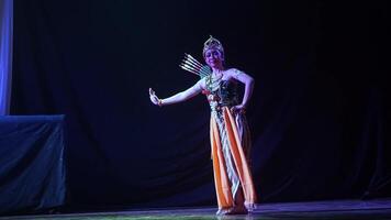 Traditional dancer performing on stage with shadow puppet screen video