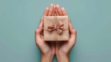 Womans Hands Holding Gift Box With Pink Bow photo