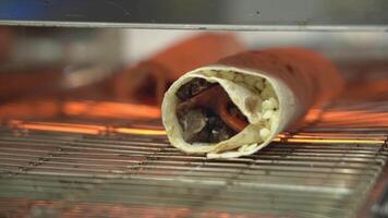 shawarma desde vegetales y carne es frito en un caliente parrilla en un rápido comida restaurante. video