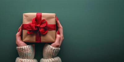 Person Holding Wrapped Gift Box With Red Bow photo