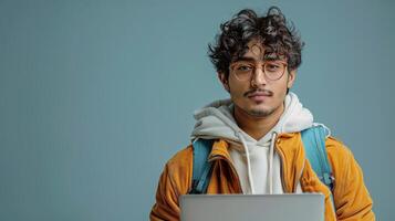 Man With Glasses and Yellow Jacket Holding Laptop photo