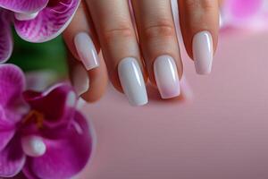 Womans Hand With White Manicure and Pink Flowers photo