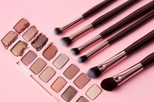 rosado superficie con varios maquillaje productos y cepillos foto