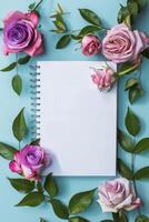 Spiral Notebook Surrounded by Pink and Purple Roses photo