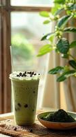 cup of green tea matcha milk ice drink is placed on the bamboo mat photo