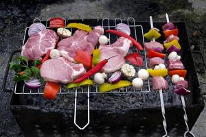 fresh raw beef shish kebab with pepper chunk on black big grill bbq Raw meat skewers with vegetables on wooden background photo