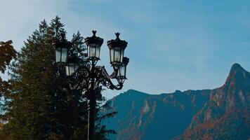 Beautiful black old-style street lantern. Autumn nature and hazy mountains at backdrop. video