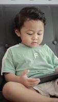 Child playing games by smartphone on sofa video