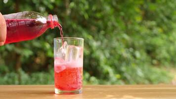 Colorful soft drinks poured into glasses and placed on the table. There is a natural background. video