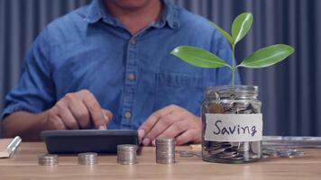 A man counting coins in a piggy bank money saving concept video